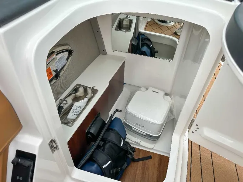 Slide: The Image of Interior of a 2026 Chaparral GTS 6 with a sink, storage, and portable toilet. - 22