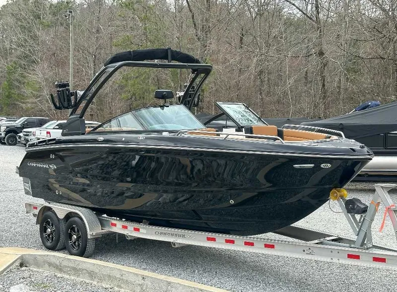 Slide: The Image of A sleek black Chaparral GTS 6 boat from 2026 on a trailer, surrounded by trees. - 5