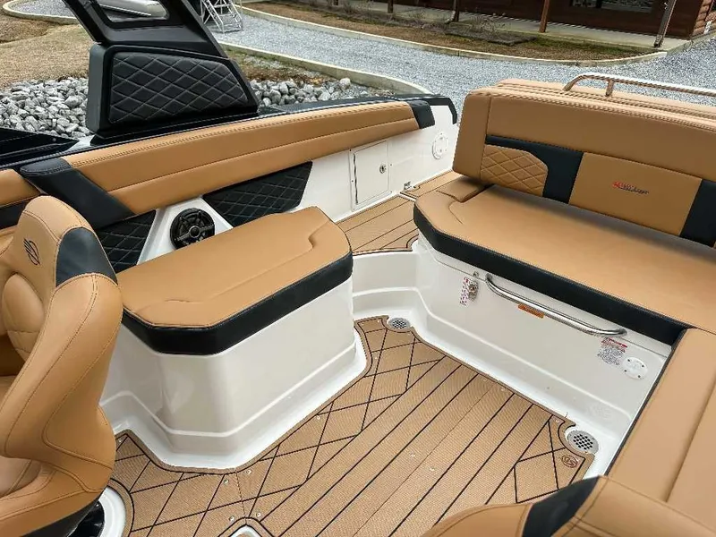 Slide: The Image of The image shows the interior of a 2026 Chaparral GTS 6 boat with sleek brown leather seating and modern design. - 25