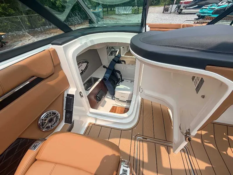 Slide: The Image of Interior of a 2026 Chaparral SSX 6 with brown leather seats and a small toilet area. - 20