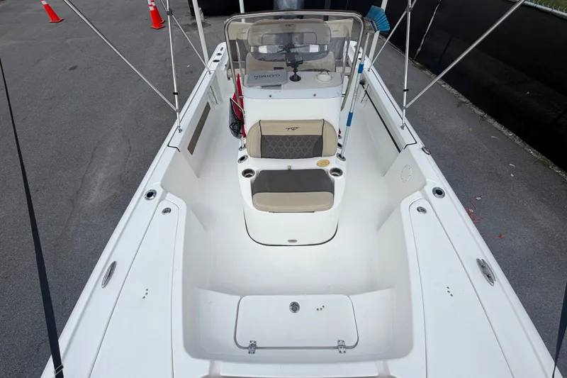 Slide: The Image of 2020 Tidewater 2110 Bay Max boat interior with seating and console, docked on pavement. - 41
