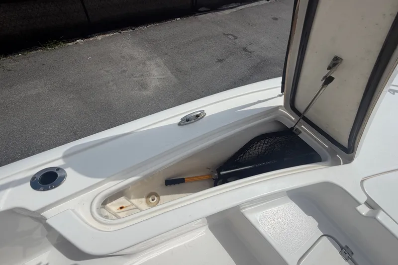 Slide: The Image of 2020 Tidewater 2110 Bay Max boat storage compartment with open hatch and fishing net. - 29