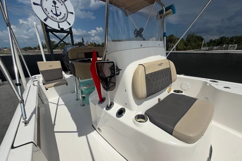 Slide: The Image of 2020 Tidewater 2110 Bay Max boat interior with seating and console, under sunny skies. - 45