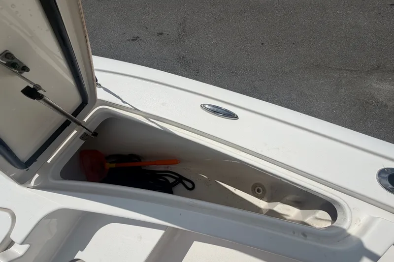 Slide: The Image of Open storage compartment on 2020 Tidewater 2110 Bay Max boat, containing a brush and rope. - 33