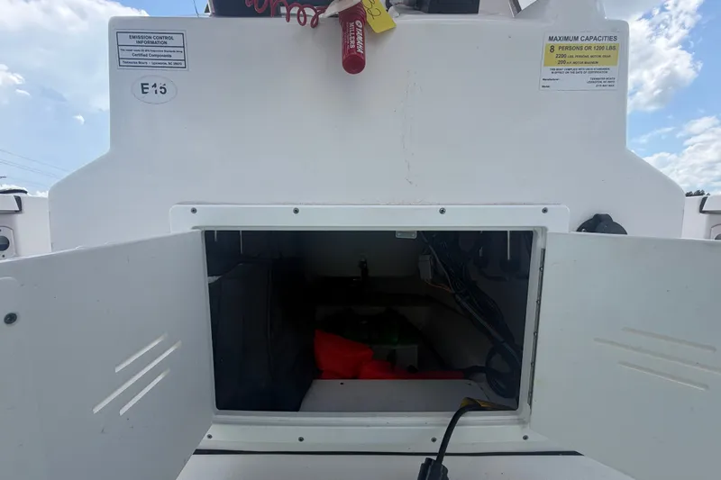 Slide: The Image of 2020 Tidewater 2110 Bay Max boat storage compartment with open hatch and visible wiring. - 23