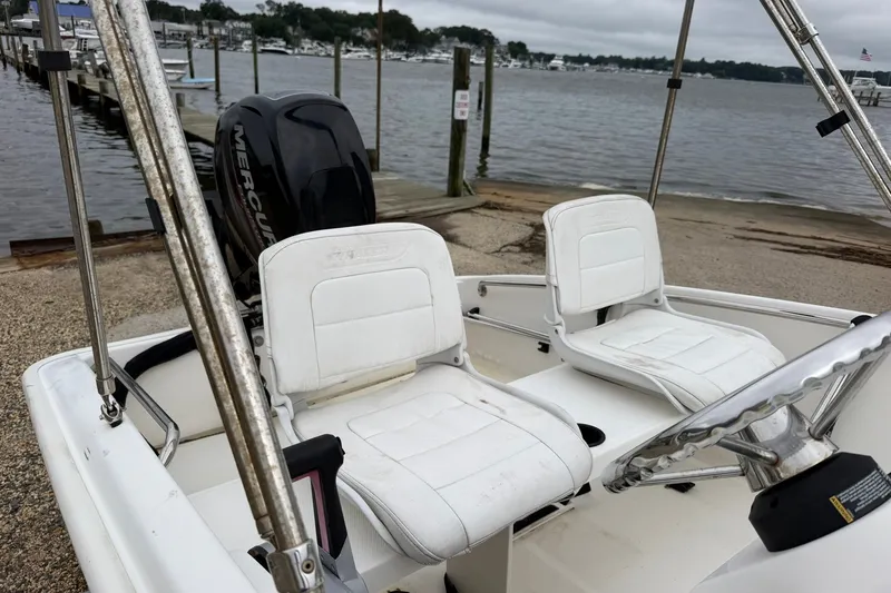 Slide: The Image of 2017 Boston Whaler 130 Super Sport boat interior with white seats and Mercury engine. - 3