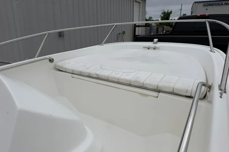 Slide: The Image of 2017 Boston Whaler 130 Super Sport boat interior with cushioned seating and railing. - 5