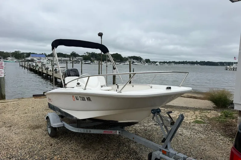 The Image of 2017 Boston Whaler 130 Super Sport boat on trailer by a marina. - 1