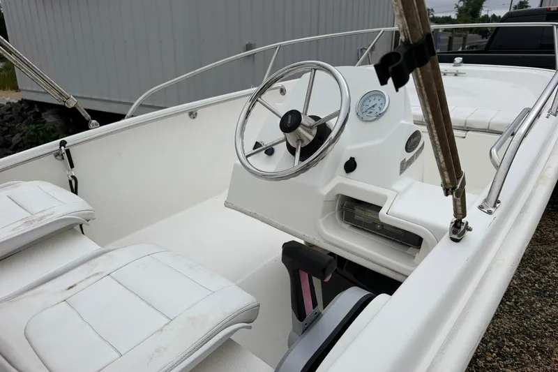 Slide: The Image of 2017 Boston Whaler 130 Super Sport boat interior with steering wheel and seating. - 4