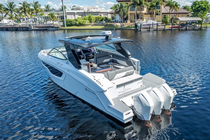 Slide: The Image of 2022 Cruisers Yachts 38 GLS OB on serene water, showcasing sleek design and powerful outboard engines. - 3
