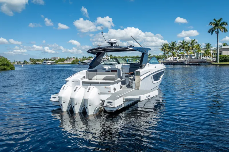 Slide: The Image of 2022 Cruisers Yachts 38 GLS OB on serene water with clear blue sky. - 2