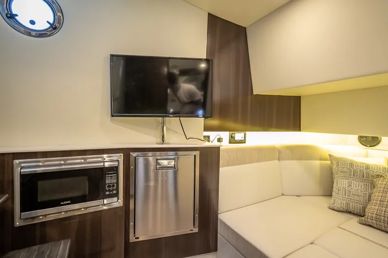 Slide: The Image of Interior of 2022 Cruisers Yachts 38 GLS OB with TV, microwave, and seating area. - 15