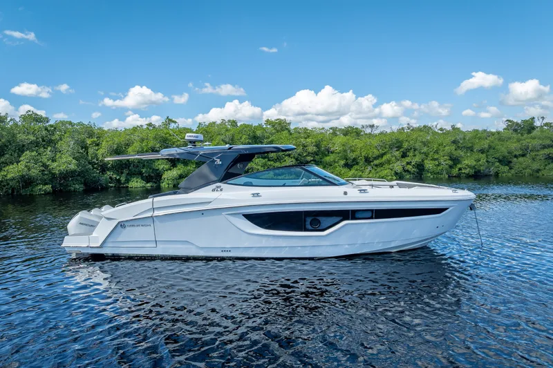 Slide: The Image of 2022 Cruisers Yachts 38 GLS OB on calm water, clear sky background. - 6