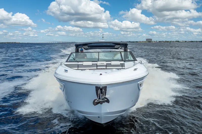 Slide: The Image of 2022 Cruisers Yachts 38 GLS OB speeding on open water under a blue sky. - 4
