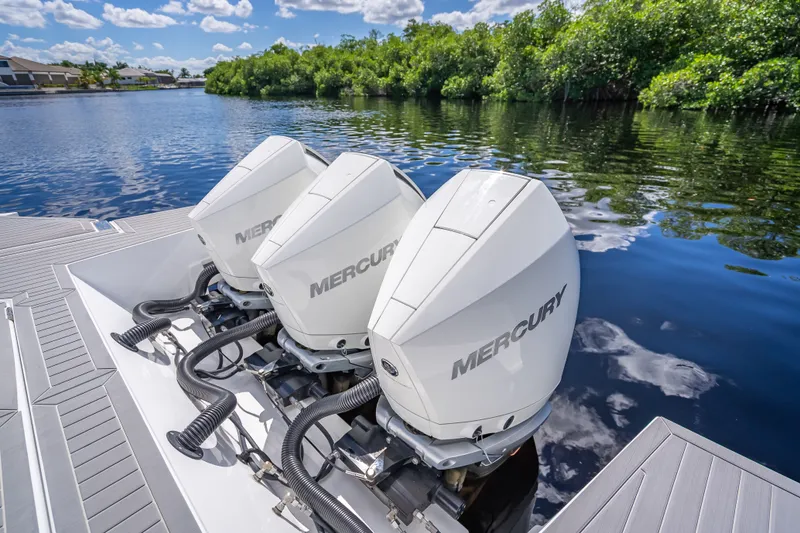 Slide: The Image of Triple Mercury outboard engines on 2022 Cruisers Yachts 38 GLS OB, docked by lush shoreline. - 36