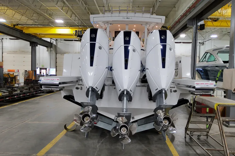 Slide: The Image of 2026 Formula 387 Center Console Fish boat with triple outboard engines in a workshop. - 7