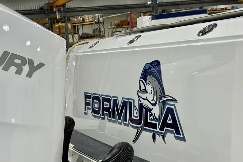 Slide: The Image of 2026 Formula 387 Center Console Fish boat with fish logo in a warehouse setting. - 6
