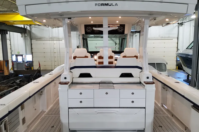 Slide: The Image of 2026 Formula 387 Center Console Fish boat interior with seating and storage in a garage. - 12