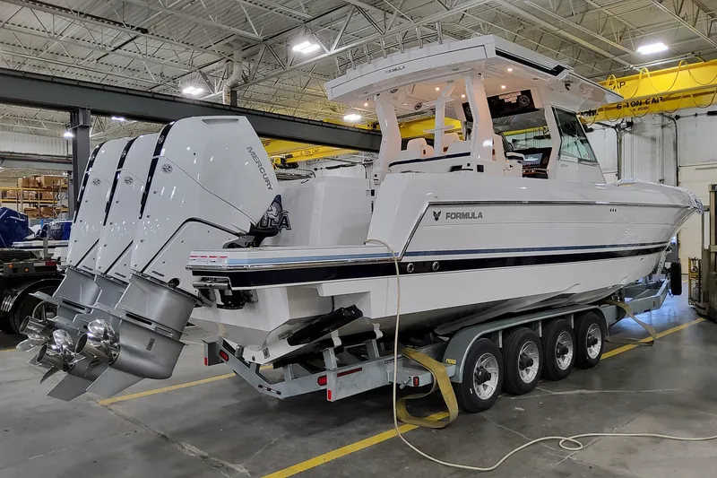 The Image of 2026 Formula 387 Center Console Fish boat with triple Mercury engines in a warehouse. - 1