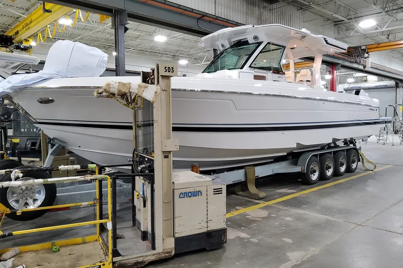 Slide: The Image of 2026 Formula 387 Center Console Fish boat in a manufacturing facility on a trailer. - 2