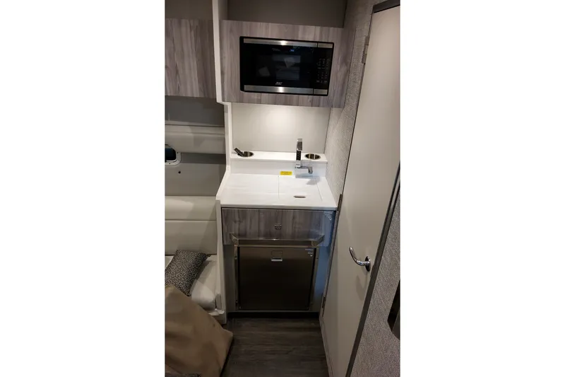 Slide: The Image of Compact kitchenette in 2026 Formula 387 Center Console Fish boat, featuring microwave and sink. - 21