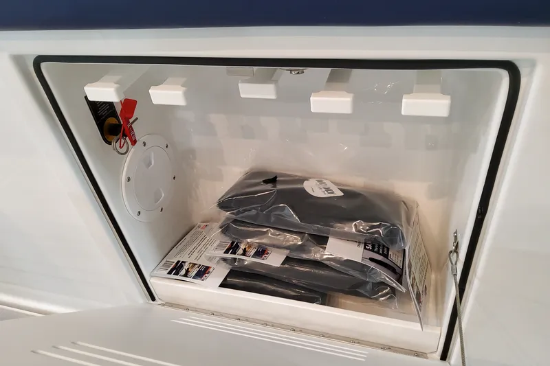 Slide: The Image of Storage compartment of 2026 Formula 387 Center Console Fish boat, containing manuals and accessories. - 25