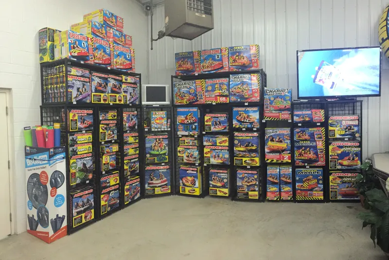 Slide: The Image of Display of colorful inflatable water sports products in a showroom with a TV screen. - 12