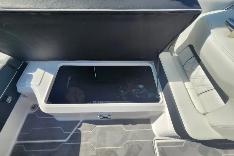 Slide: The Image of Open storage compartment in 2022 Regal LS6 boat with cushioned seating. - 28