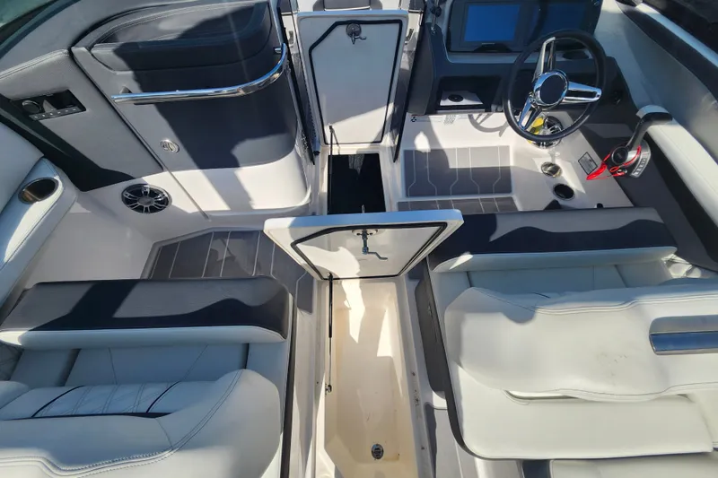 Slide: The Image of 2022 Regal LS6 boat interior with open storage, steering wheel, and seating. - 13