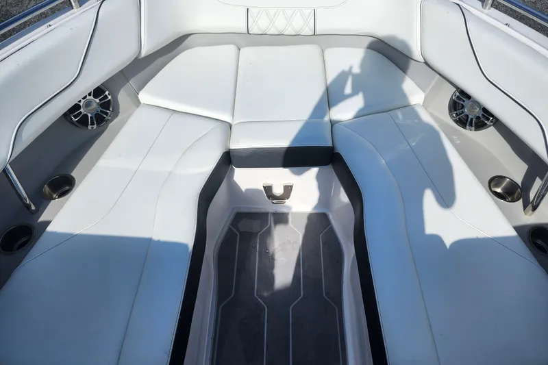 Slide: The Image of Interior of a 2022 Regal LS6 boat with white cushioned seating and cup holders. - 21