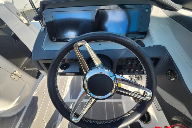Slide: The Image of 2022 Regal LS6 boat dashboard with steering wheel and dual displays. - 17
