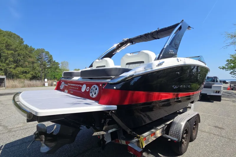 Slide: The Image of 2022 Regal LS6 boat on trailer, featuring sleek black and red design. - 3