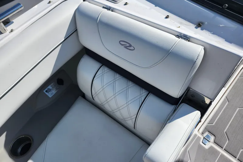 Slide: The Image of 2022 Regal LS6 boat interior with white cushioned seating and elegant stitching. - 25