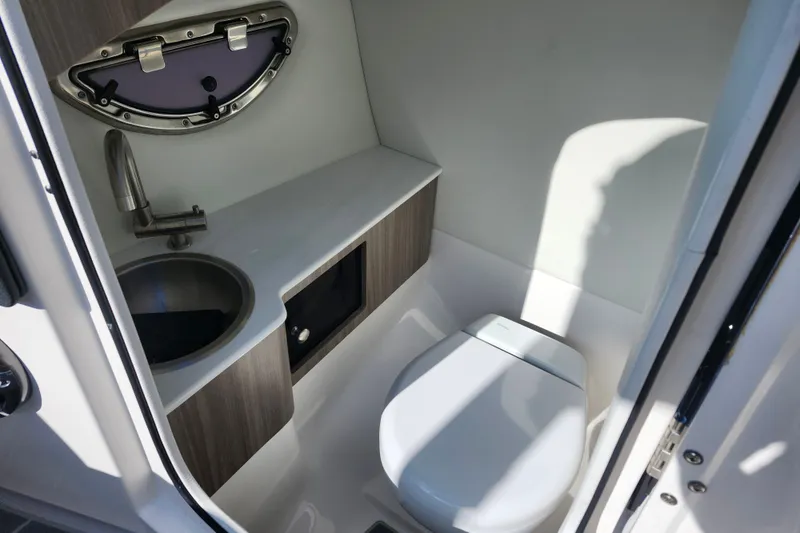 Slide: The Image of 2022 Regal LS6 boat bathroom with sink, toilet, and window. - 15