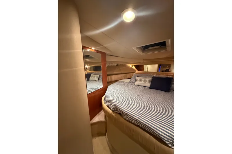 Slide: The Image of Interior cabin of 2001 Sea Ray 380 Sundancer with cozy bed and ambient lighting. - 13