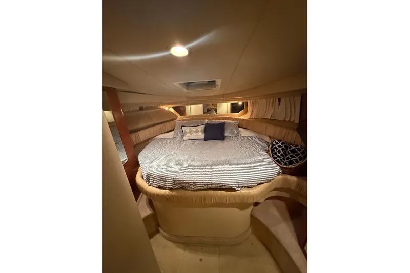 Slide: The Image of Cozy cabin interior of 2001 Sea Ray 380 Sundancer with striped bedding and cushions. - 12