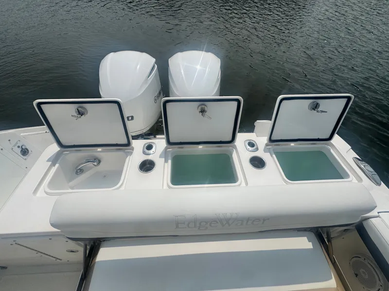 Slide: The Image of The image shows the stern of an Edgewater 280CX Crossover with three open storage compartments. - 14