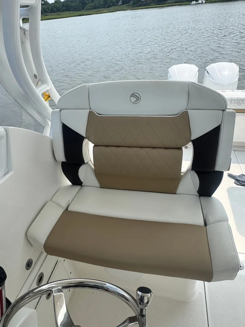 Slide: The Image of A luxurious seat on an Edgewater 280CX Crossover boat, overlooking calm waters. - 24