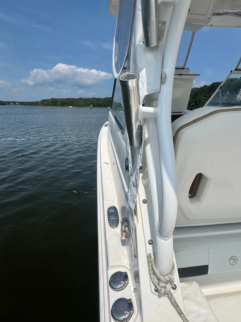 Slide: The Image of A 2018 Edgewater 280CX Crossover on calm water. View of the deck and railing. - 17