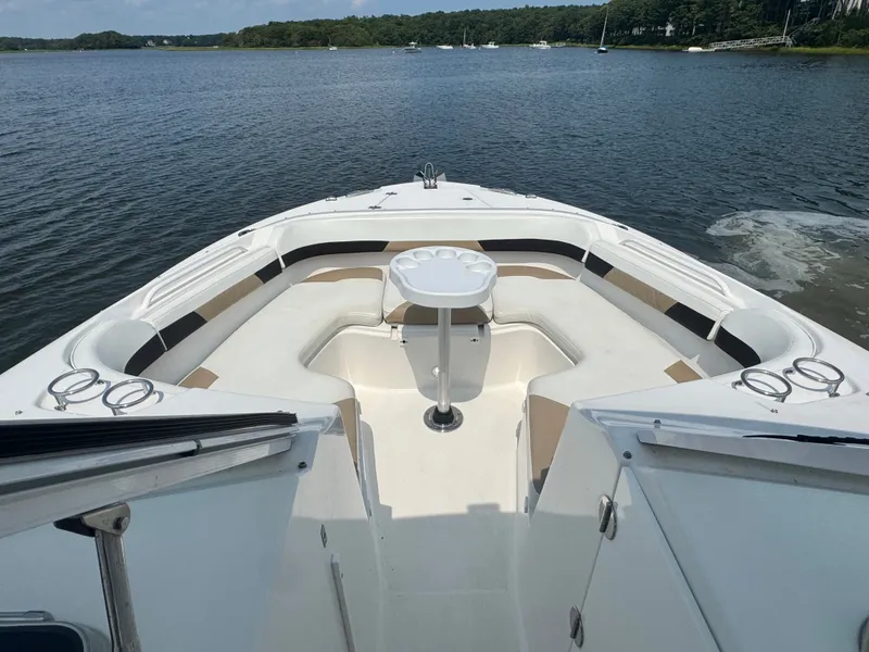 Slide: The Image of The image shows the bow of a 2018 Edgewater 280CX Crossover with seating and a table. - 21