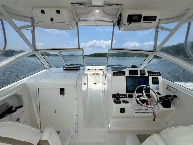 Slide: The Image of The cockpit of a 2018 Edgewater 280CX Crossover with a modern helm and panoramic view. - 11