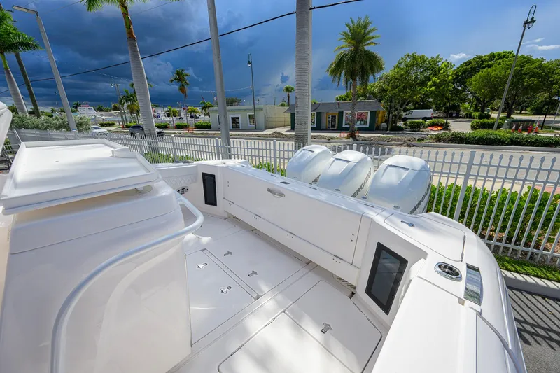 Slide: The Image of 2022 Intrepid 409 Valor boat with triple outboard engines, docked near palm trees. - 29