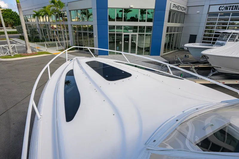 Slide: The Image of 2022 Intrepid 409 Valor boat displayed outside a modern showroom. - 9