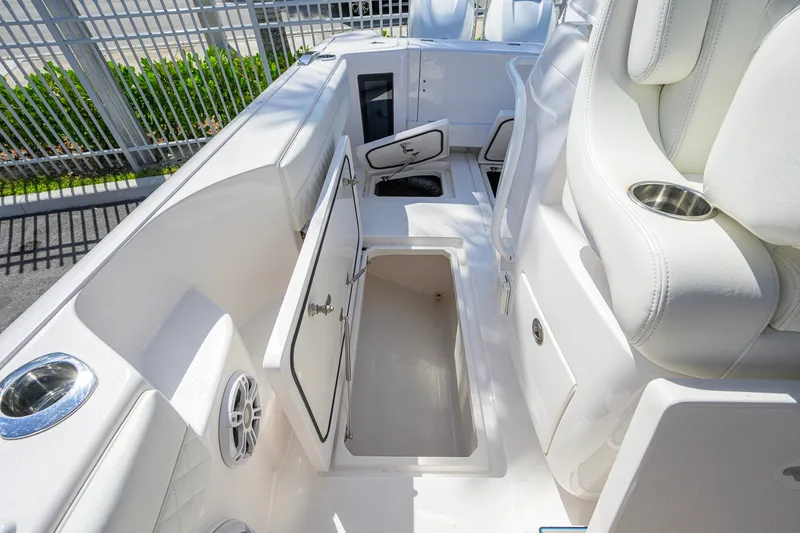 Slide: The Image of 2022 Intrepid 409 Valor boat interior with open storage compartments and white seating. - 47