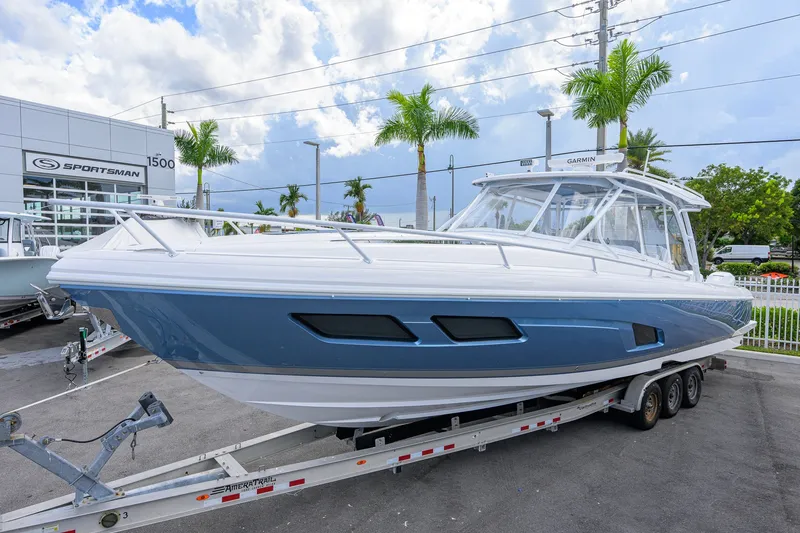 Slide: The Image of 2022 Intrepid 409 Valor boat on trailer at dealership, under a cloudy sky. - 2