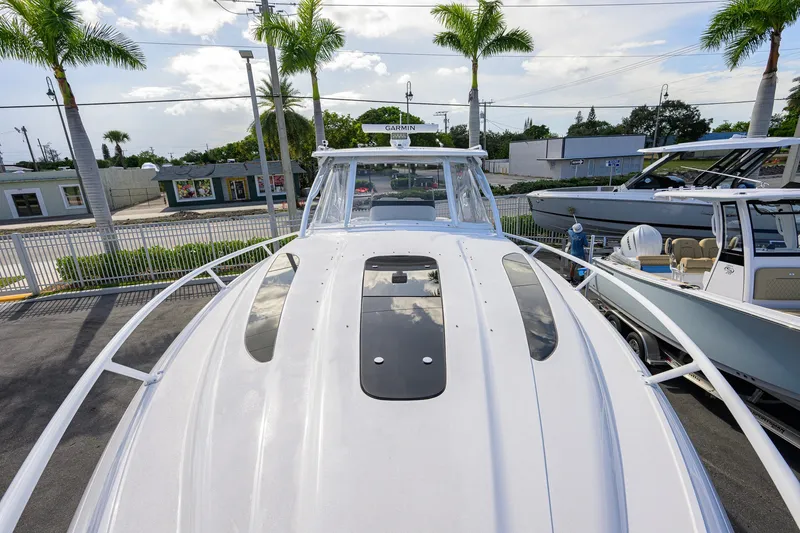 Slide: The Image of 2022 Intrepid 409 Valor boat, docked with palm trees and buildings in the background. - 11