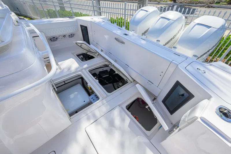 Slide: The Image of 2022 Intrepid 409 Valor boat deck with open storage compartments and Mercury engines. - 46