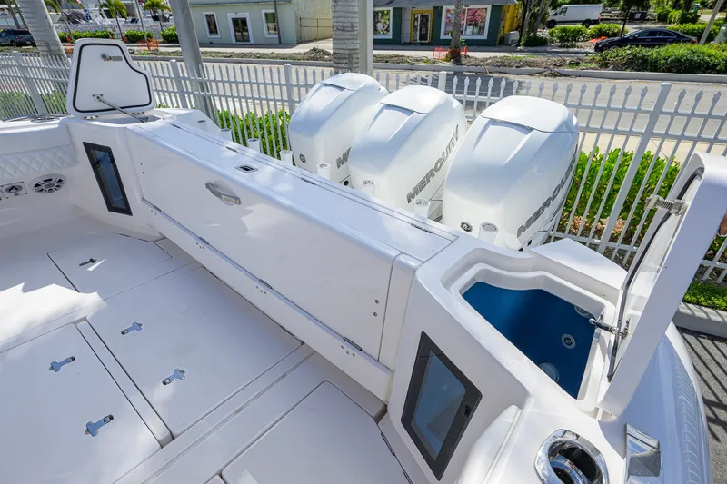 Slide: The Image of 2022 Intrepid 409 Valor boat with triple Mercury engines, spacious deck, and storage compartments. - 51