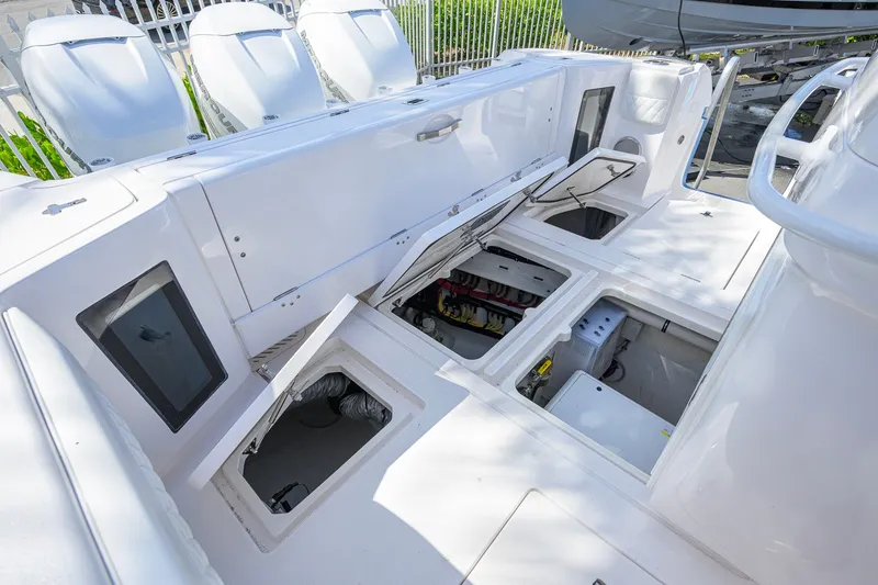 Slide: The Image of 2022 Intrepid 409 Valor boat with open storage compartments and visible engines. - 48