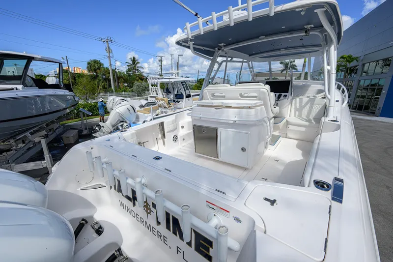 Slide: The Image of 2022 Intrepid 409 Valor boat with spacious deck and seating, docked outdoors. - 35